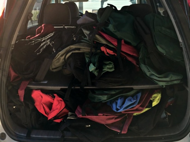 car full of empty backpacks